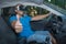 Man with virtual reality glasses sitting in car and showing thumbs up