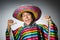 Man in vivid mexican poncho against gray