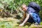 Man wahsing his face with forest brook river