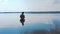 A man waist-deep in water stands in a forest lake