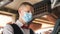 Man or waiter in medical mask at counter with cashbox working at bar or restaurant