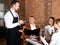 Man waiter receiving order from guests