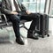 Man waiting for his flight at the airport and looking at a mobile phone