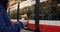 Man waiting tram, engrossed smartphone. Scene depicts urban life, with focus smartphone use. Man tram stop scrolling