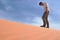 Man walking alone in the sunny desert. He is lost and out of breath. No water and energy.