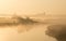 Man walking along banks of river on misty morning