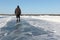 Man walking along a road of ice on the frozen reservoir