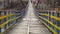 Man is walking along on a rope suspension bridge