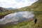 Man walking along the shore of a glacial lake