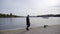 Man walking along a waterfront promenade