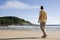 Man walking barefoot on a tropical beach