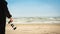 Man walking on beach with camera