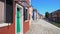 Man walking on beautiful street with multicolored houses in Burano, Venice
