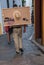 Man walking with canvas and hat behind his back in the city of Cordoba