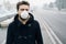 Man walking in city wearing mask against smog air pollution