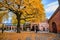 A man walking in the courtyard of the Oslo Cathedral in the autumn The trees in the garden