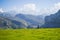 A man walking in Covadonga Lakes, Asturias, Spain. Green grassland with mountains at the background