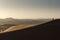 Man walking on dunes of Desert Sahara with beautiful lines and colors at sunrise. Merzouga, Morocco