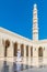 Man walking through the exterior courtyard of the Sultan Qaboos Grand Mosque in Muscat