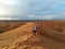 Man walking in the highest dune of the sahara desert