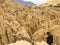 Man walking in the maze of Moon Valley or Valle De La Luna among eroded sandstone spikes, near La Paz, Bolivia