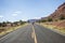 A man walking in the middle of the road in wilderness of Utah