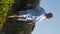 Man walking mountain path with yoga mat in sunlight. Guy go nature park vertical