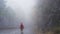 Man walking on a mountain road with a lot of fog in rainy day. Lost, wandering concept