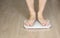 Man walking on scales measure weight. male wal checking BMI weight loss. human barefoot measuring body fat overweight