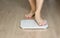 Man walking on scales measure weight. male wal checking BMI weight loss. human barefoot measuring body fat overweight