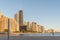 Man walking shoreline with Chicago skyscraper in background at s