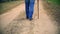 Man with walking stick walking away down the road