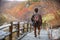 A man walking on the street and red yellow maple tree in autumn season, taken from Hokkaido Japan. Beautiful view in Jigokudani