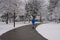 Man walking at Toronto waterfront Martin Goodman trail during heavy snowstorm, wet snow covering trees and branches.