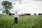 Man walking towards the pasture with pails of feed for the cows.