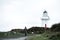 A man walking at Waipapa point, the lighthouse, ocean and cloudy. I