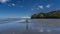 A man walks along the coast at low tide. Nosy Be