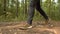 Man Walks along the Forest. Tourist in Boots Going along the Road on the Background a Beautiful Landscape. Travel