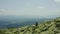 A man walks along a mountain slope covered with giant stones. Solo tourism.