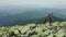 A man walks along a mountain slope covered with giant stones. Solo tourism.