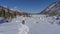 A man walks along a path trodden in the snow.