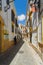 The man walks along the shady side of a narrow street at the height of a hot day, during a siesta