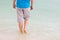 A man walks barefoot on the beach of the Dead Sea