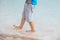 A man walks barefoot on the beach of the Dead Sea