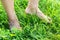 The man walks barefoot on the green dewy grass, hardening