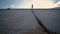 A man walks into the distance.In the foreground are concrete slabs.