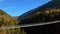 Man walks on hanging rope river bridge in forest