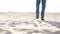 A man walks over the wreckage of an old barge on the beach