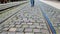 The man walks the pavement from the paving stones, along the tram tracks