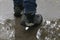 A man walks through puddles. Rainy day. Wet asphalt. Boots